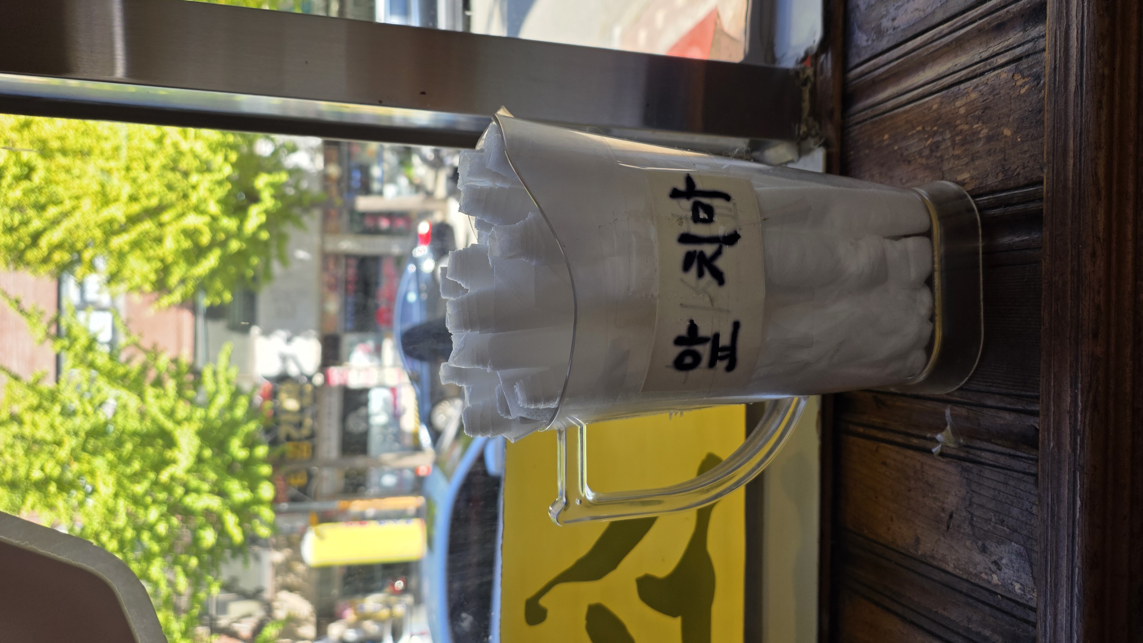 Folded aprons in a container labeled “aprons” by the window