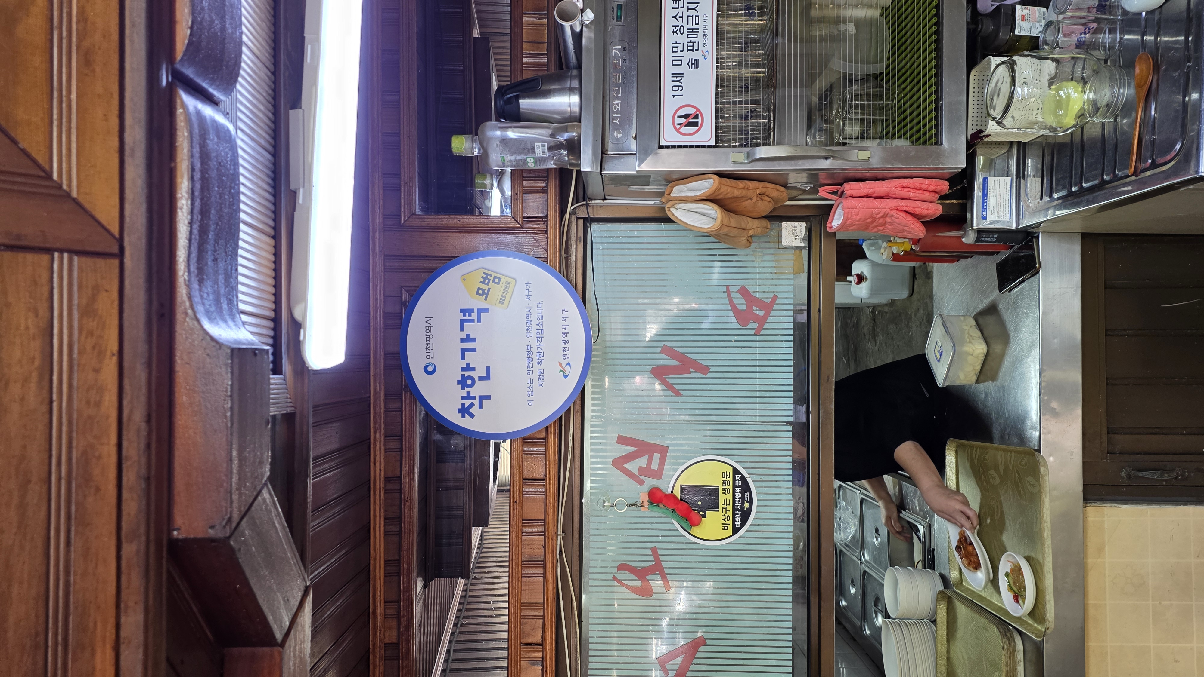An Incheon and Seo-gu Good Price Business sign hanging by the kitchen